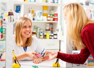 pharmacist handling medicine tablets to the customer